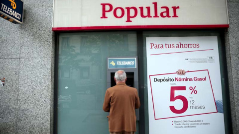 Un hombre retira dinero de un cajero de una sucursal del Banco Popular en Madrid. | EFE