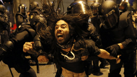 La policía desaloja a un manifestante del interior de un inmueble tras la manifestación por calles de Santiago de Compostela.- EFE