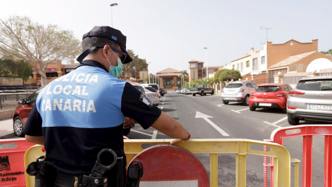 Un agente de policía coloca una valla para prohibir el paso al hotel situado en el municipio tinerfeño de Adeje. - EFE