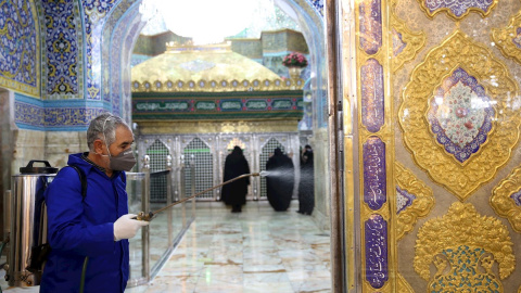 Un miembro del personal desinfecta el Santuario Masumeh en la ciudad de Qom, Irán. - EFE