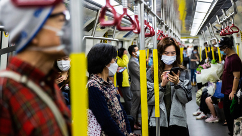 Pasajeros en el metro de Hong Kong con mascarillas de protección. - AFP