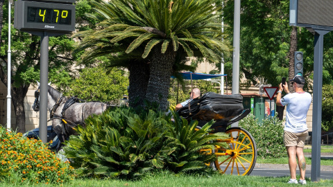 Imágenes de personas al lado de un termómetro en las calles de la capital hispalense a 47 grados de temperatura en Sevilla.- Francisco J. Olmo / Europa Press