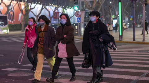 Peatones con mascarilla en una calle de Shanghai. - EUROPA PRESS