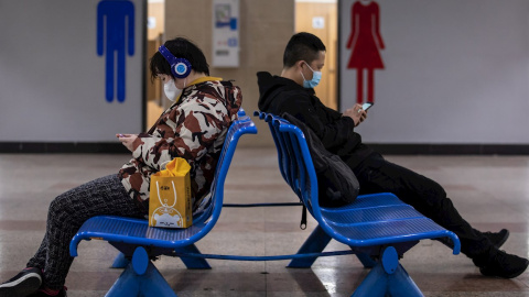 Dos personas con mascarilla en una estación de tren en Shanghai. - EFE