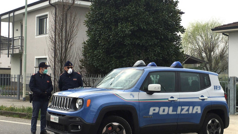 Dos operarios de la Policía Local italiana hacen guardia este martes en uno de los puestos de control para entrar en un municipio en cuarentena en la "zona roja" de Lombardía, a 45 kilómetros de Milán. - EFE