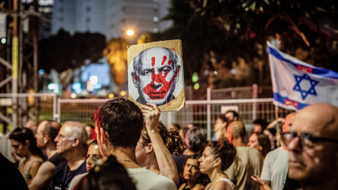  Un manifestante israelí sostiene un cartel que muestra el rostro del Primer Ministro israelí Benjamín Netanyahu con la palma ensangrentada. Foto: Eyal Warshavsky/SOPA Imágenes vía ZUMA Press Wire/dpa