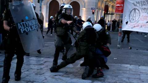 Policías griegos se abalanzan sobre un manifestante. /REUTERS