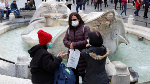 Turistas con máscaras protectoras descansan junto a la fuente de Barcaccia en Roma, Italia. REUTERS / Remo Casilli