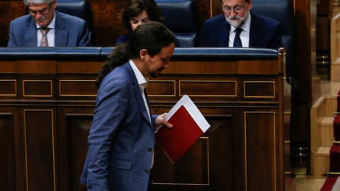 El líder de Podemos, Pablo Iglesias, pasa por delante del presidente del Gobierno, Mariano Rajoy, sentado en su escaño, durante la moción de censura. REUTERS/Juan Medina