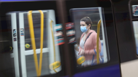 Una pasajera con mascarilla en un tren en la estación de metro de Sol en Madrid este lunes en el que la Comunidad de Madrid, el área metropolitana de Barcelona y amplias zonas de Castilla y León activan las medidas de alivio del confinamiento de la con