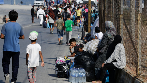 Refugiados y migrantes del destruido campamento de Moria hacen fila para ingresar a un nuevo campamento temporal durante una operación policial, en la isla de Lesbos. REUTERS / Elias Marcou