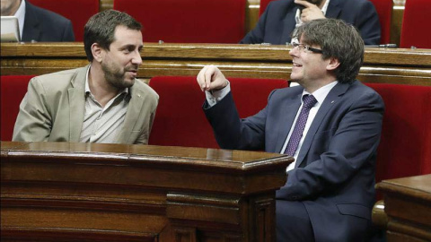 El presidente de la Generalitat, Carles Puigdemont, junto al conseller de Salud, Toni Comín (izquierda) en el Parlament de Catalunya. | ANDREU DALMAU (EFE)