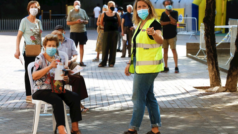 Varias personas esperan para acceder a la zona de realización de PCR durante el primer día de cribados masivos de covid-19 en El Raval de Barcelona. /EFE