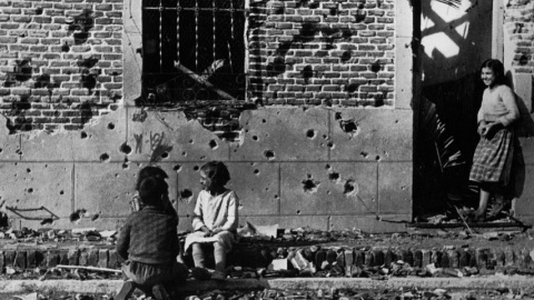 Robert Capa  Los niños juegan ajenos al horror de la guerra ante la fachada destrozada  por la metralla del número 10 de la calle Peironcely, November-December  1936  ©International Center of Photography/Magnum Photos