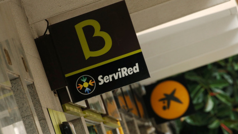 Los logos de Bankia y de Caixabank, en sendas sucursales en el centro de Madrid. REUTERS/Albert Gea