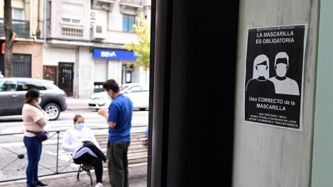 Unos vecinos conversan en la Avenida de la Albufera en el distrito del Puente de Vallecas que será confinado este lunes / EFE