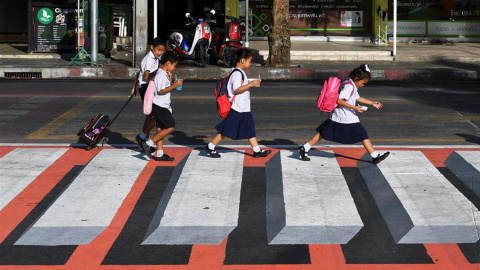 Niños cruzan un paso de cebra en 3D en Bangkok. / REUTERS