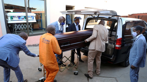 Operarios de una funeraria transportan un féretro en Sudáfrica. | REUTERS