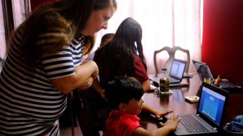 Una madre ayuda a sus dos hijos menores con el colegio online mientras su padre ayuda a su hija mayor en el condado de Broward, Florida, EE.UU. Alejandra Cardona / Reuters / Archivo