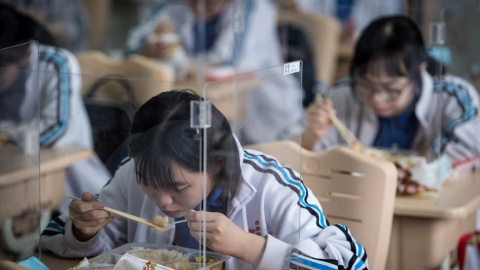 Alumnos de la escuela secundaria almorzando durante su último día en la escuela secundaria antes del Examen de ingreso a la universidad nacional (NCEE), el 7 de julio de 2020. / STR / AFP