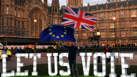 Un manifestante anti-Brexit ondea banderas frente a las Casas del Parlamento en Londres, | Reuters