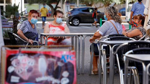 Una vecinas descansan en la terraza de un bar del barrio de la Pastoreta de Reus (Tarragona) donde este lunes se han reanudado los cribados masivos de PCR a los vecinos. /EFE