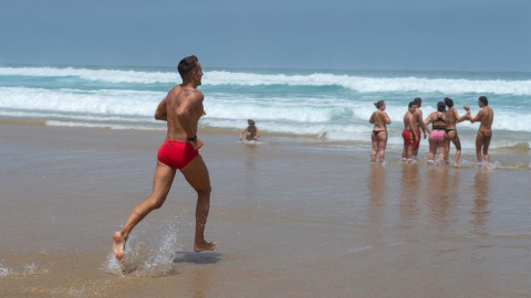 Varias personas disfrutan del baño en la orilla de la playa de Cofete, en el municipio de Pájara, en la isla de Fuerteventura. EFE/ Carlos de Saá