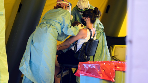 Personal sanitario realiza pruebas PCR a un niño en el colegio José María Pereda del barrio de La Inmobiliaria en la ciudad cántabra de Torrelavega. /EFE