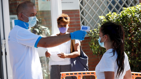 21/08/2020.- Un paramédico toma la temperatura a una ciudadana antes de acceder al centro de salud Reyes Católicos, de la localidad madrileña San Sebastián de los Reyes, durante la realización de pruebas PCR a vecinos de Alcobendas, este viernes. EFE