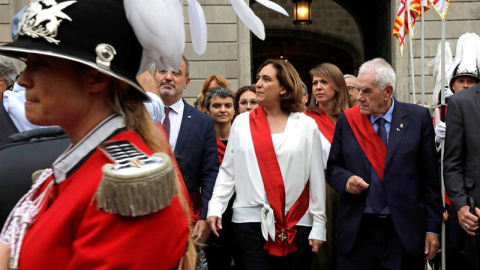 La alcaldesa Ada Colau, junto a Jaume Collboni y Ernest Maragall, cruzan la Plaza de Sant Jaume hacia el Palau de la Generalitat entre los gritos y abucheos del público asistente, hoy sábado en Barcelona. EFE/Susanna Sáez