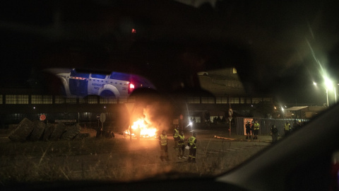 Trabajadores controlan el acceso de los empleados en servicios mínimos durante el cambio de turno a la entrada de la factoría de Alcoa, custodiada por la Guardia Civil. MANU BRABO