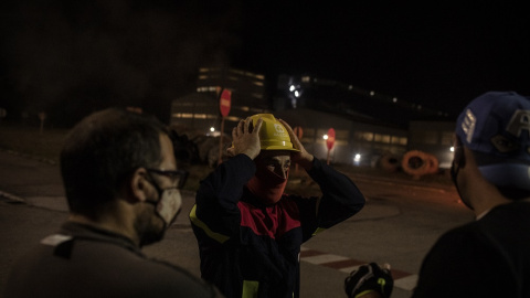 Trabajadores debaten sobre próximas acciones de protesta mientras guardan una de las barricadas a la entrada de la factoría. MANU BRABO