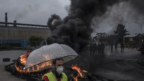 Un trabajador de Alcoa frente a una barricada en la entrada de la factoría de Alcoa custodiada por la Guardia Civil en San Cibrao, Lugo. MANU BRABO