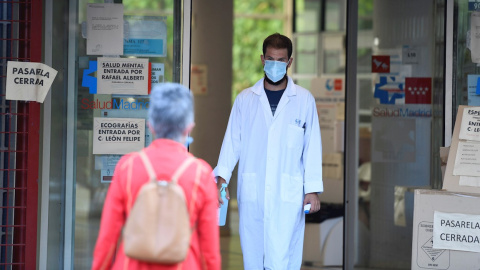 Un sanitario recibe a una paciente termómetro en mano en el centro de salud Federica Montseny en el distrito de Puente de Vallecas en Madrid.-EFE