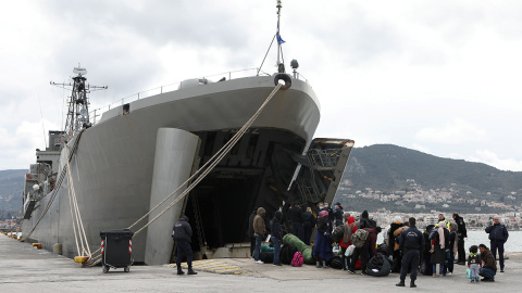 Un grupo de refugiados embarca en el buque militar enviado por el Gobierno griego a la isla de Lesbos.- REUTERS