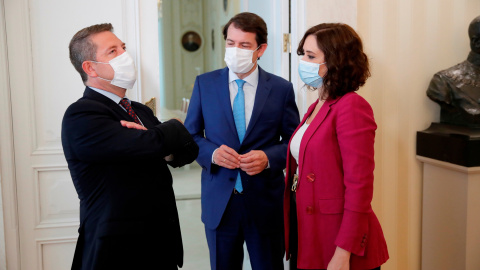 La presidenta de la Comunidad de Madrid, Isabel Díaz Ayuso (d), conversa con sus homólogos de Castilla y León, Alfonso Fernández Mañueco (c), y de Castilla-La Mancha, Emiliano García-Page, durante la reunión que mantuvieron para coordinar actuacion