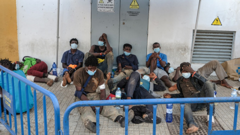 Las personas migrantes que acaban de sortear la valla de Melilla esperan a las afueras de la Plaza de Toros./ José Palazón