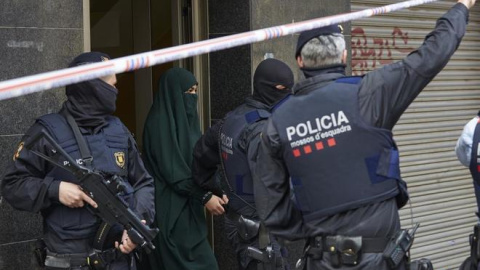 Agentes de los Mossos d'Esquadra detienen a una joven en el marco de una operación contra el terrorismo yihadista. ALEJANDRO GARCIA (EFE)