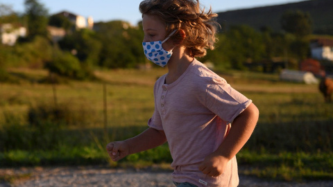 Un niño con mascarilla para protegerse del coronavirus, en Suances (Cantabria). PEDRO PUENTE HOYOS (EFE)