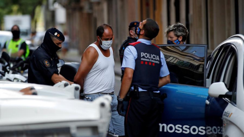 Mossos d'esquadra custodian a uno de los detenidos en la operación contra el terrorismo yihadista que llevan a cabo desde primera hora de la mañana en el distrito de Ciutat Vella de Barcelona. EFE/Toni Albir