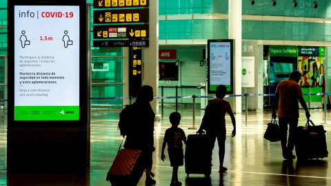 Viajeros con máscaras sanitarias caminan por la Terminal 1 del aeropuerto Josep Tarradelles - El Prat, en Barcelona. EFE/ Enric Fontcuberta