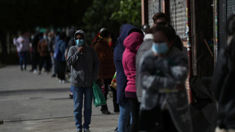 Personas haciendo cola en la calle para recibir alimentos, como ayuda de una asociación vecinal en Madrid. REUTERS/Susana Vera