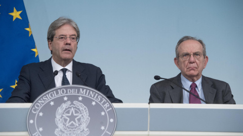 El primero ministro italiano, Paolo Gentiloni (i), con el ministro de Economía, Pier Carlo Padoan (d), en la comparecencia ante los medios en el Palacio Chigi, sede del Consejo de Ministros, para informar sobre la liquidacion de los banco Veneto Banca y 