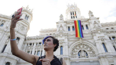 Una mujer se fotografía junto a la fachada del Ayuntamiento de Madrid donde hoy se ha desplegado la bandera del orgullo gay en una semana en la que tendrá lugar la celebración del World Pride 2017, en la capital española. EFE/Juan Carlos Hidalgo