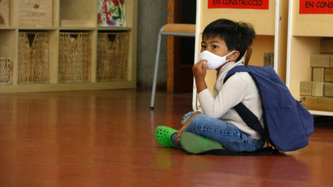 Un alumne d'infantil de l'Institut Escola Costa i Llobera, assegut amb mascareta, esperant per entrar a l'aula. Blanca Blay