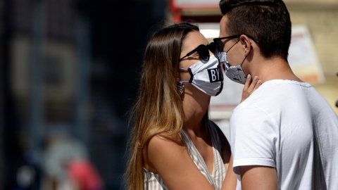 Una pareja con mascarilla mientras se besan. Europa Press / Archivo