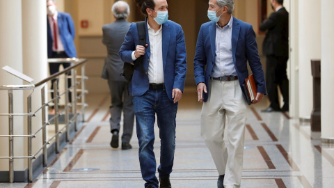 El vicepresidente segundo del Gobierno, Pablo Iglesias, y su jefe de gabinete, Julio Rodríguez, en los pasillos del Senado, antes de una sesión de control al Gobierno. EFE/ Chema Moya