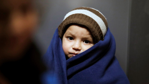 Un niño se tapa tras cruzar en patera la frontera hacia Lesbos.  REUTERS/Umit Bektas