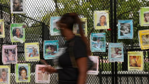 Una mujer pasa por delante de fotografías de personas asesinadas por la Policía, colgadas en una valla de seguridad cerca de la Casa Blanca. REUTERS / Jonathan Ernst