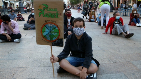 Manifestant amb una pancarta reivindicativa en la protesta organitzada a Tarragona per denunciar l'emergència climàtica. ACN/Mar Rovira